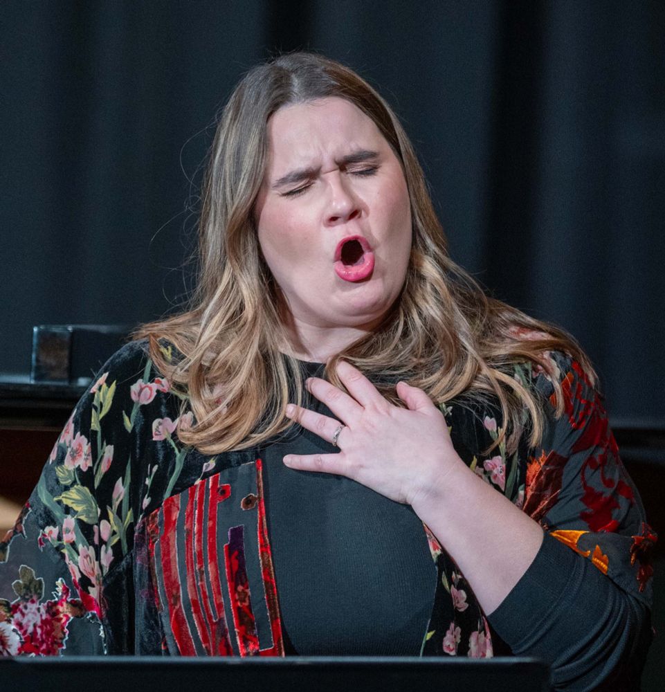 A woman with blond hair singing opera.