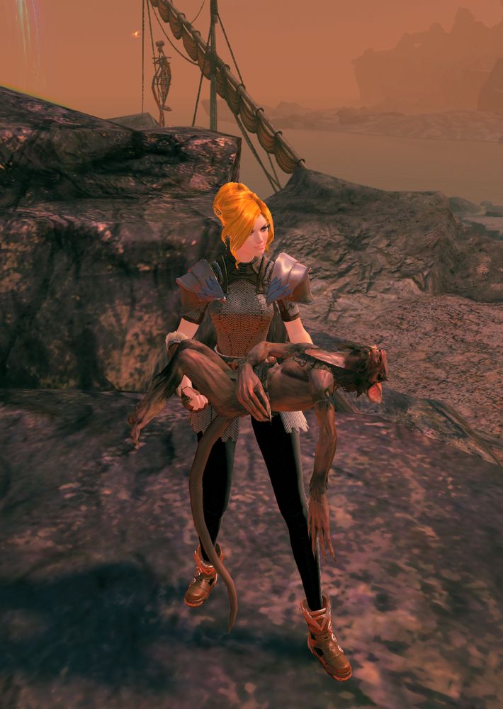 A screenshot from Guild Wars 2.  A blonde woman in chainmail armour and large pauldrons holding a passed out humanoid rat creature in her arms.  The rat creature is a Skritt.  She's standing on rocks in front of a bay with ship masts in the background.  The whole picture is tinted kinda red because it's a volcanic island.