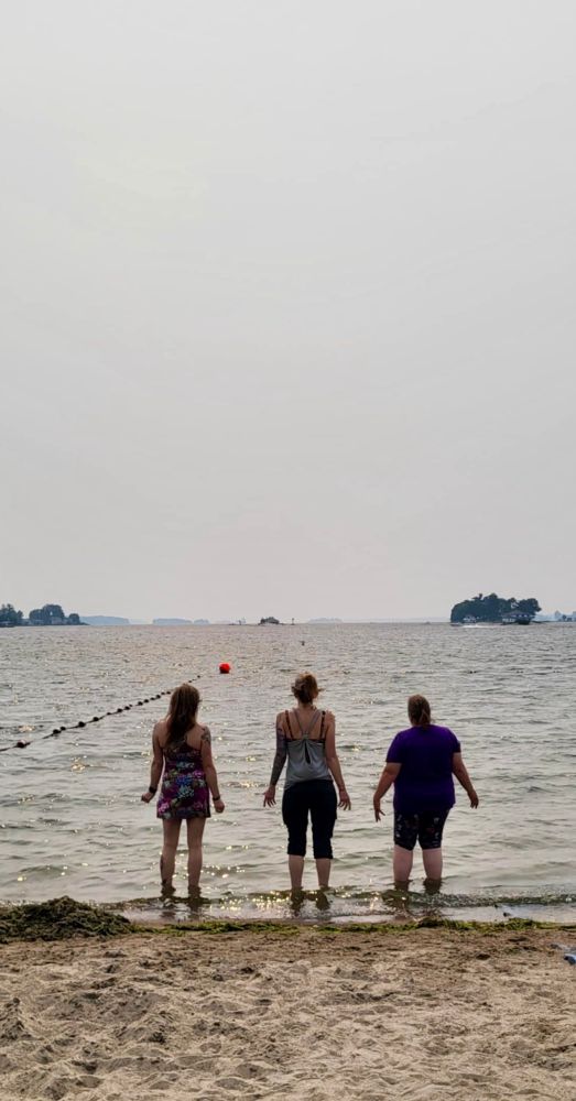 Three women stand in the wate