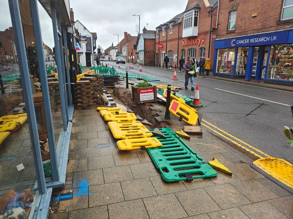 Roadworks with with the surrounding fencing all blown over & lying in the road. 