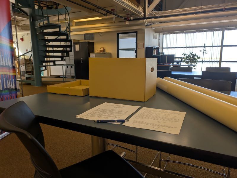 An image of a set of donated records with a deed of gift and a stewardship form laid out on a table in the reading room of the UW Archives.
