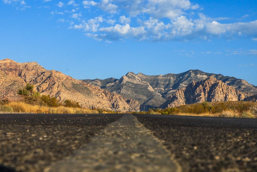 A asphalt road stretching into Red Rock Canyon National Conservation Area in Las Vegas Nevada. 