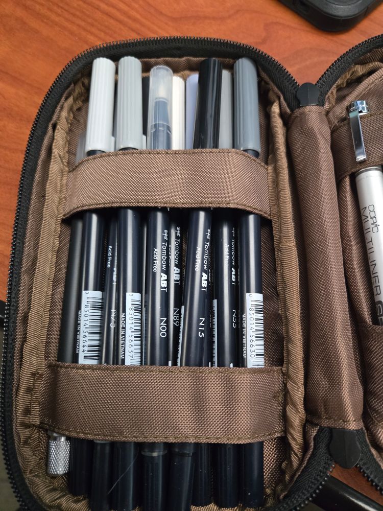 A set of Tombow ABT dual-ended markers in varying shades of warm and cool gray.