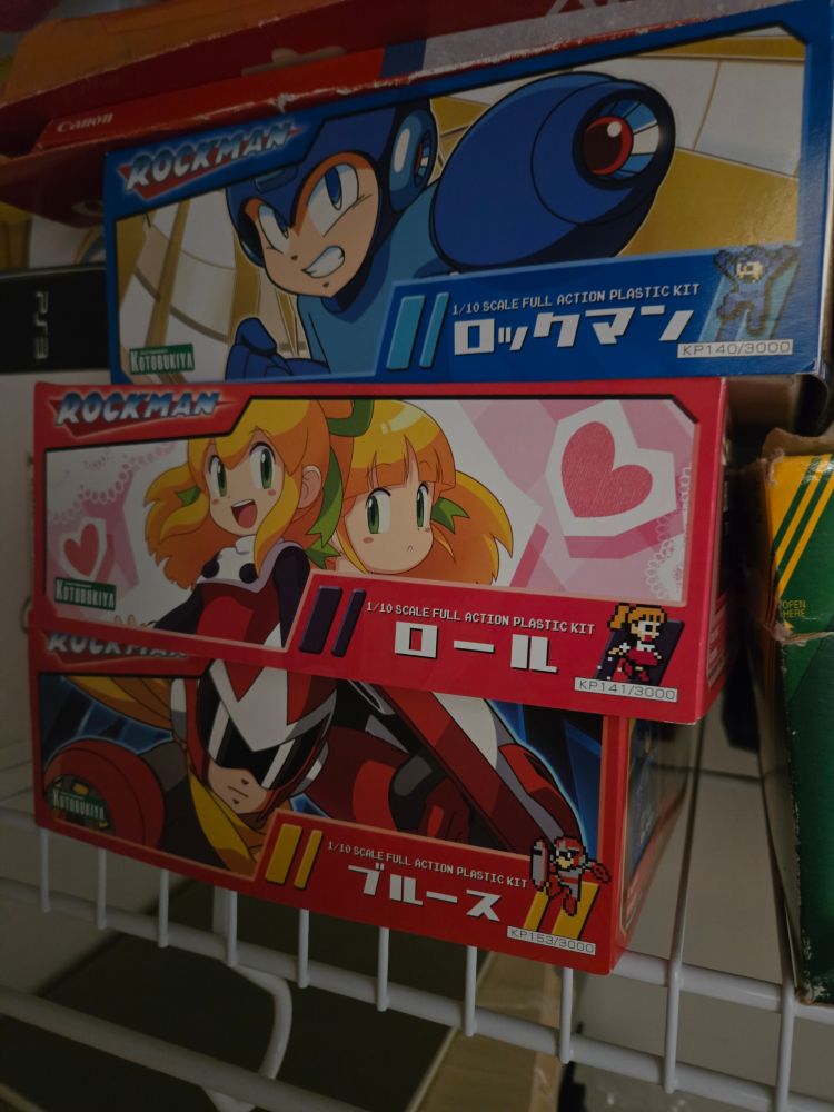Duplicate boxed kits for Mega Man, Roll and Proto Man, sitting on the top shelf of my hobby closet