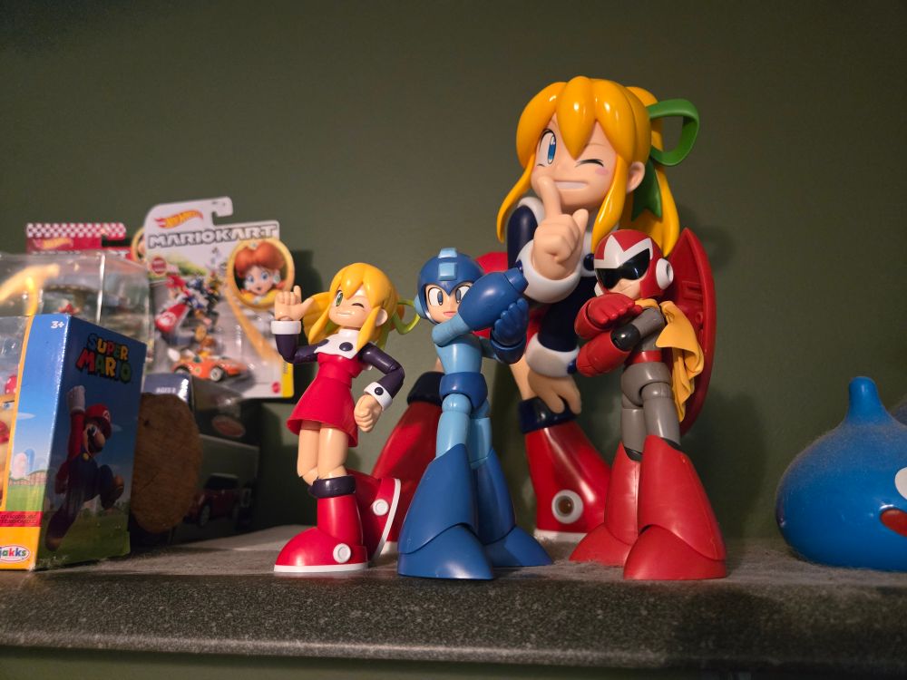 The assembled Kotobukiya Mega Man classic model kits, standing on the dusty display shelf above my desktop PC