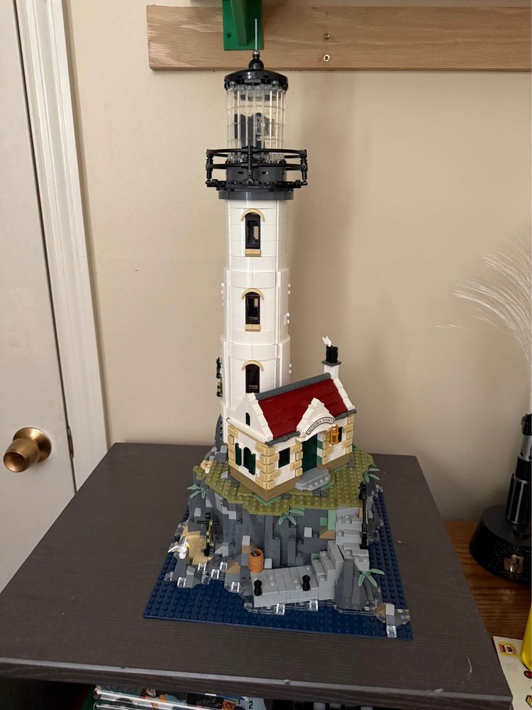 Lego lighthouse on a black shelf top. 