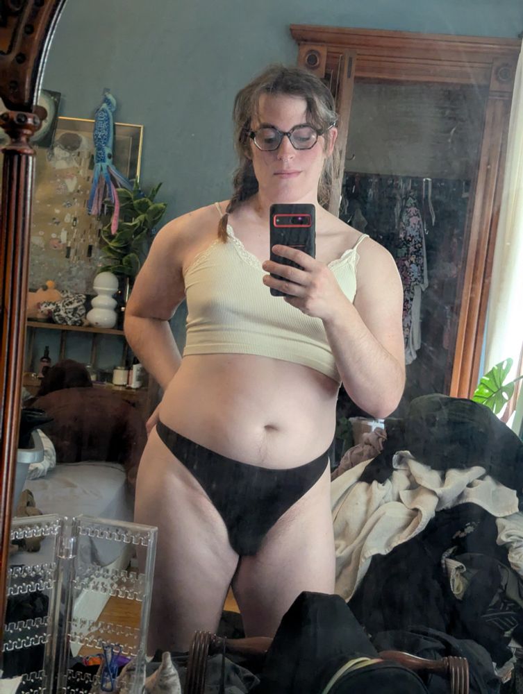 Me posing in front of a mirror dressed only in a bralett and panties.