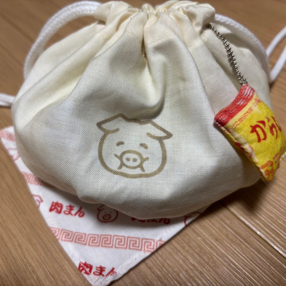 ユザワヤで購入したカットパネルクロスから作った肉まん巾着袋に、同じくからしマスコットを付けたものです