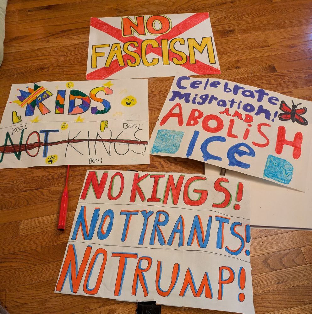 Protest signs that read, "No Fascism", "Kids, Not Kings", "Celebrate Migration and Abolish Ice", "No Kings! No Tyrants! No Trump!"