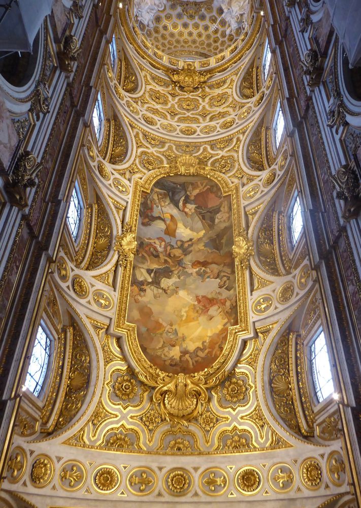 An ornate golden ceiling with six windows using a wide angel lens.