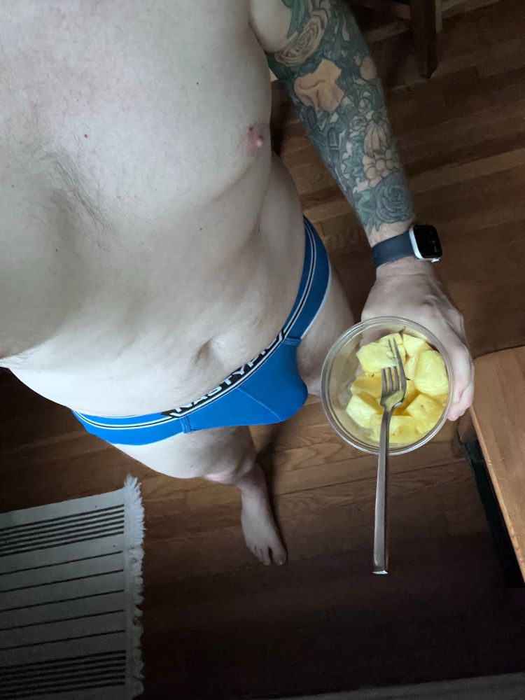 Me, standing, wearing only bulging blue briefs, holding a tub of pineapple chunks