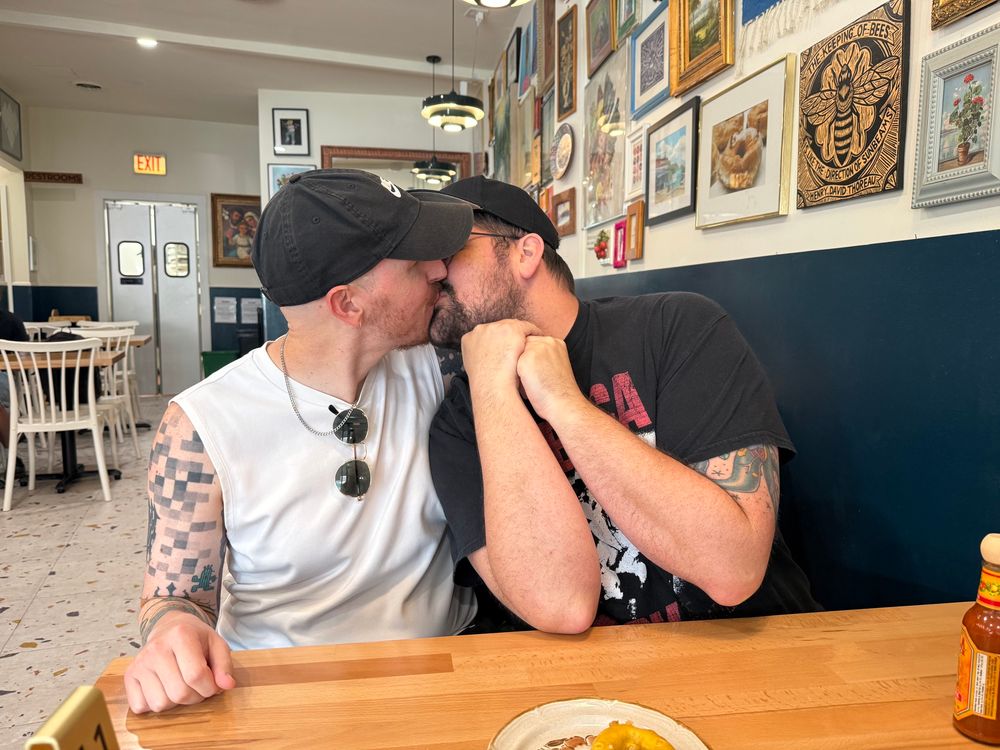 Me kissing my husband at a diner in a super fucking gay way. 