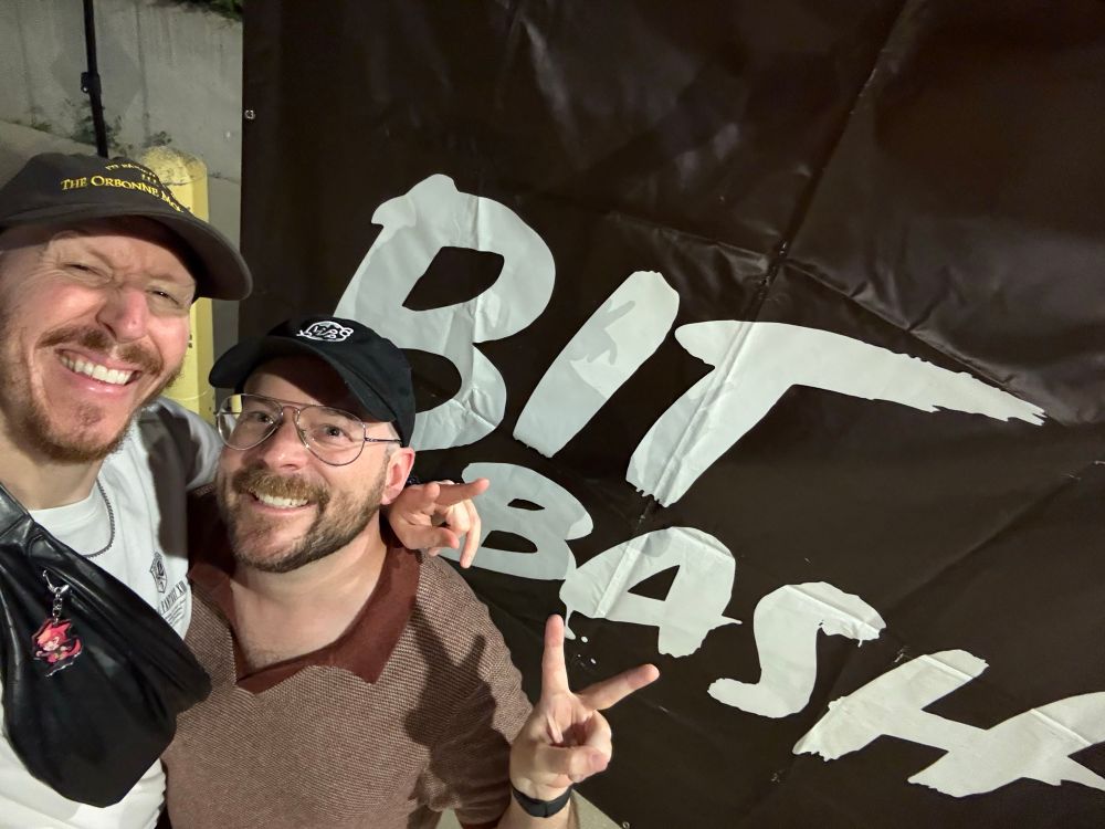 Me and Topher posing in front of a Bit Bash sign. 