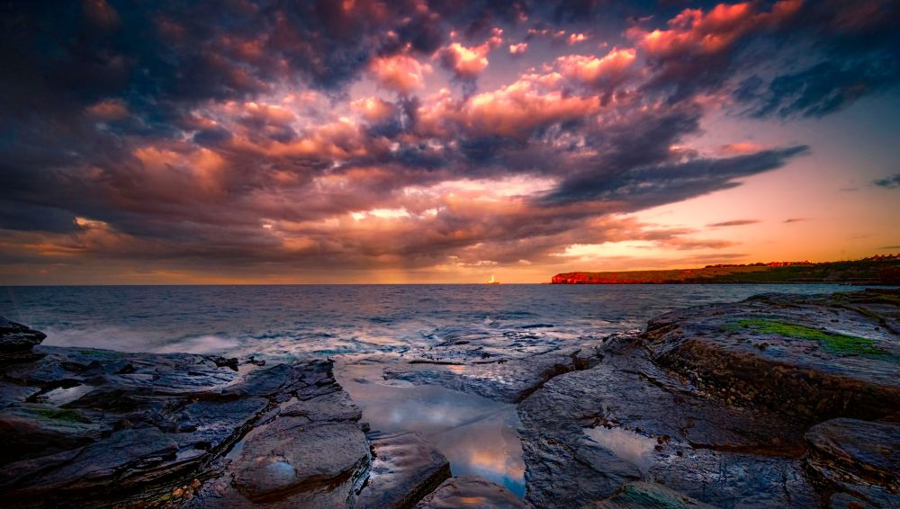 A beautiful dawn sky over the distant St. Marys Lighthouse in the UK.
