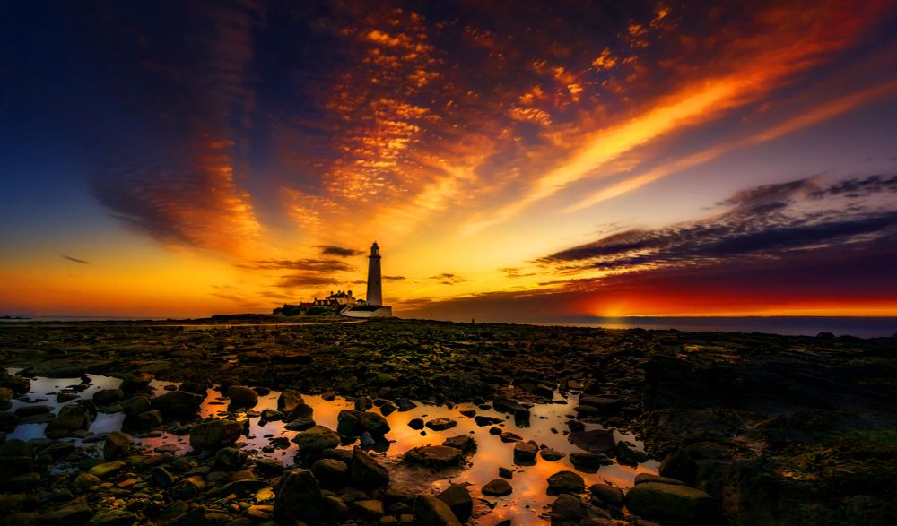 A fiery dawn at St. Marys Lighthouse in the UK.