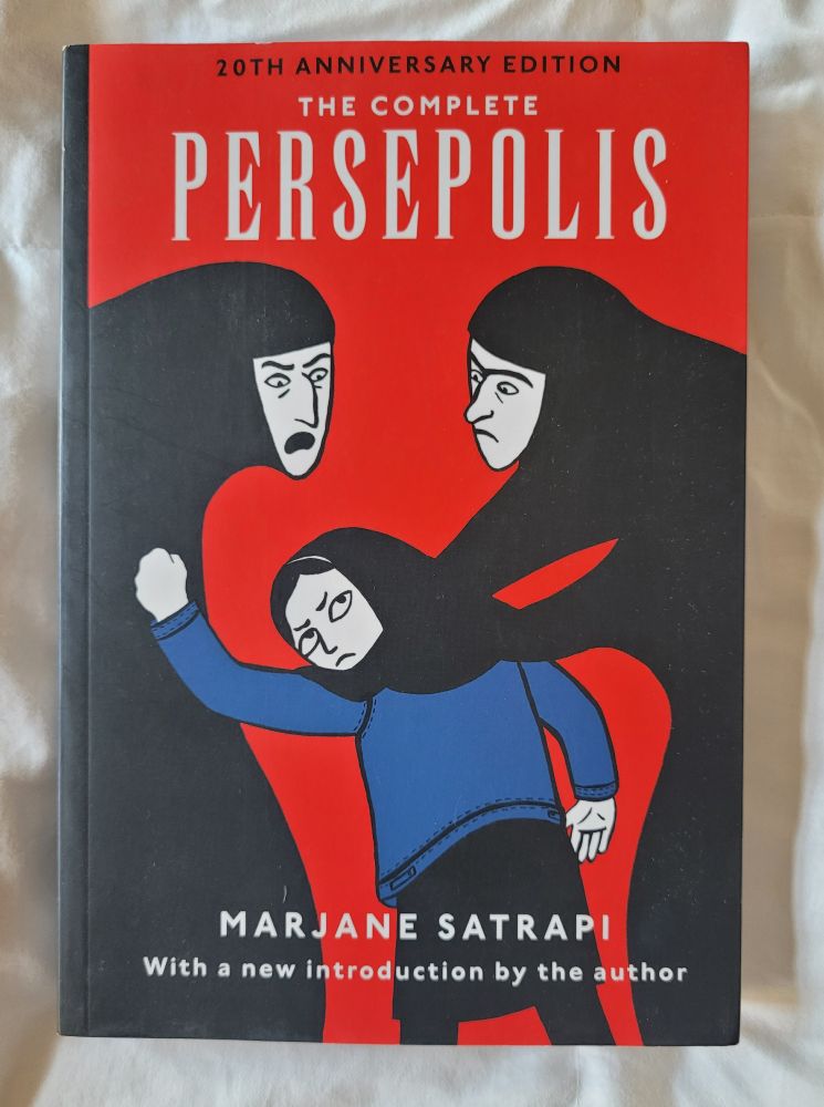 Photo of the graphic novel The Complete Persepolis by Marjane Satrapi with a new introduction by the author. Cover colors are red, black, blue, and white, with an illustration of two women next to an unhappy looking young girl. 