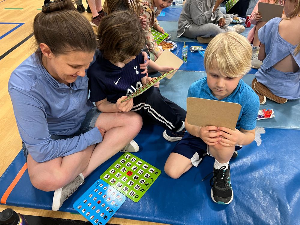 Mom with sons sitting on a mat ready to play BINGO