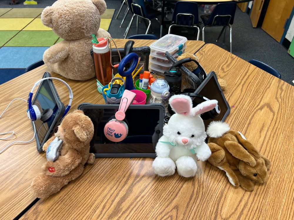 K students displayed their stuffed animals on the table by their iPads