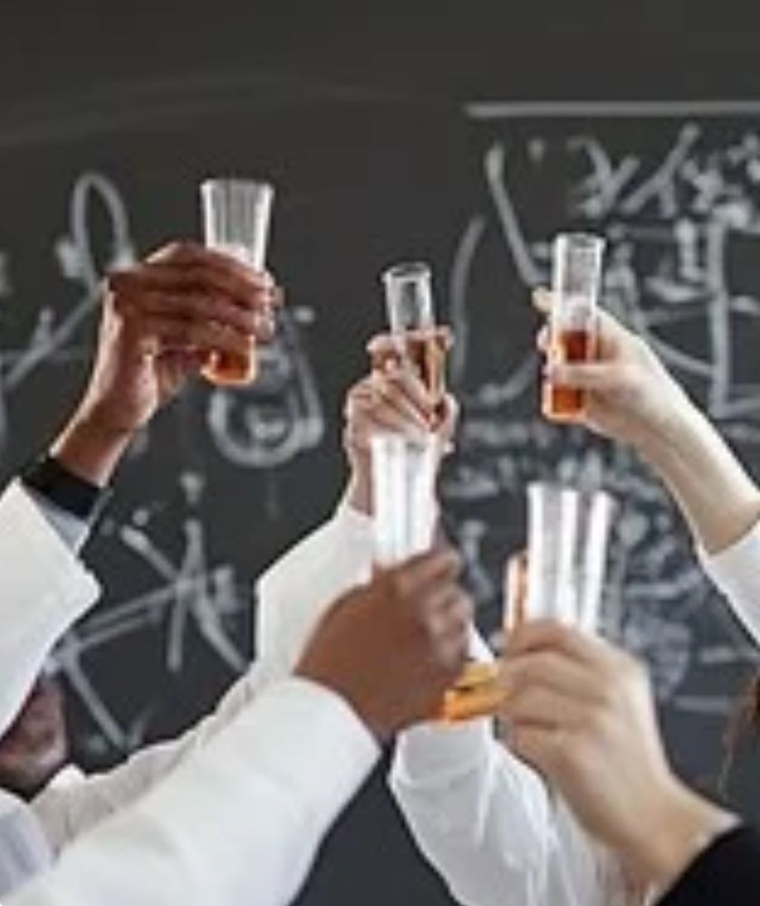 Hands raising a toast with test tubes.