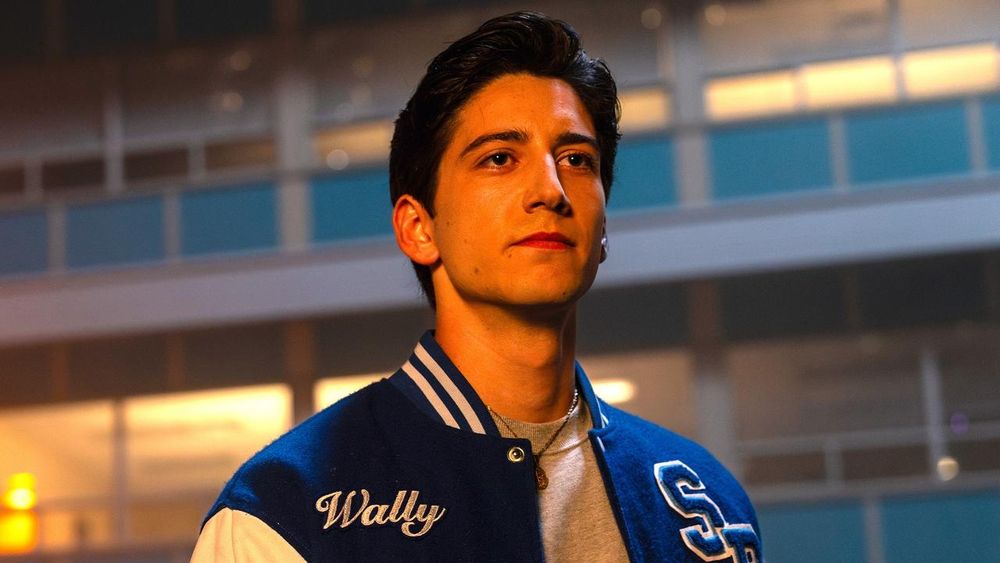 Wally, un muchachillo de piel clara y pelo negro con una bomber deportiva con su nombre grabado