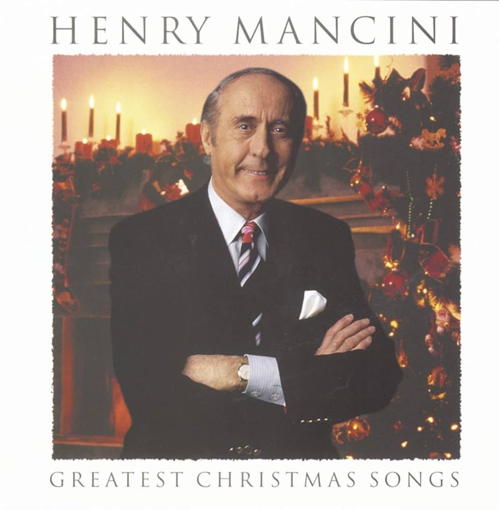 The cover of the Henry Mancini album entitled "Greatest Christmas Songs", it features a photograph of Henry Mancini in a black suit with a white pocket square and a blue-and-white striped tie. His arms are crossed, and he is smiling at the camera. The background appears to be a fireplace surrounded by pine boughs, red candles, and other Christmas decor.