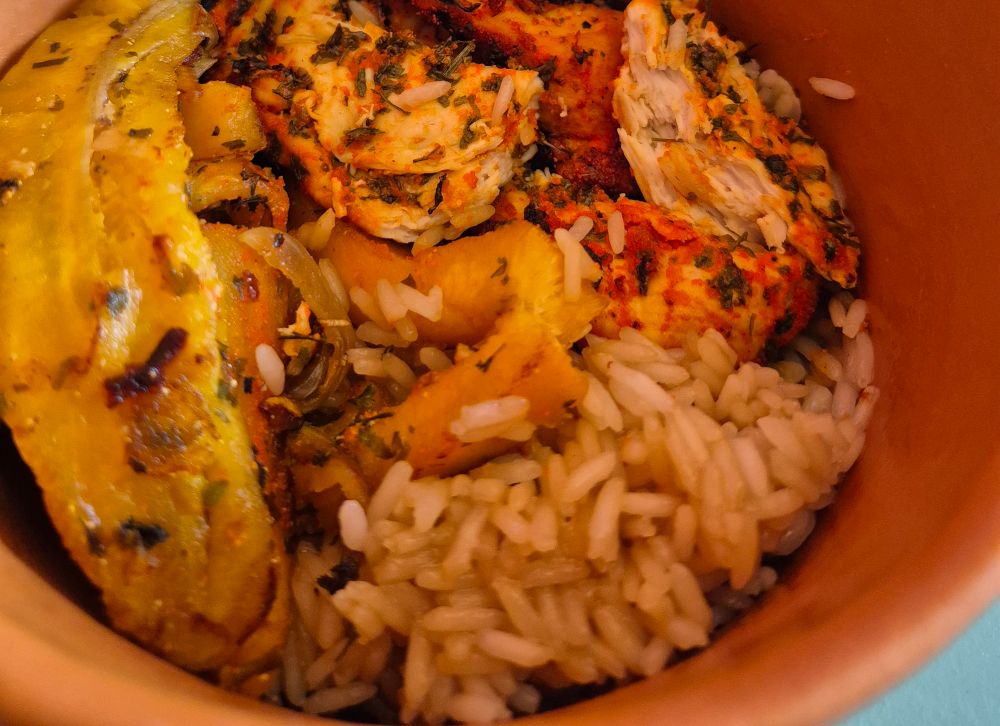 Fotografia de uma cumbuca de arroz, frango apimentado e banana da terra que eu fiz, no outro dia não tirei foto mas fiz strogonoff com batata assada pra bruna e dands. 