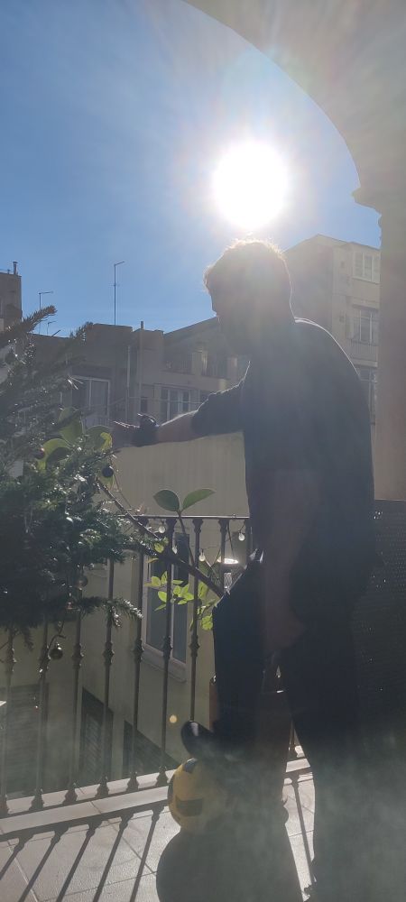 Silueta a contraluz de un señor amando plantas