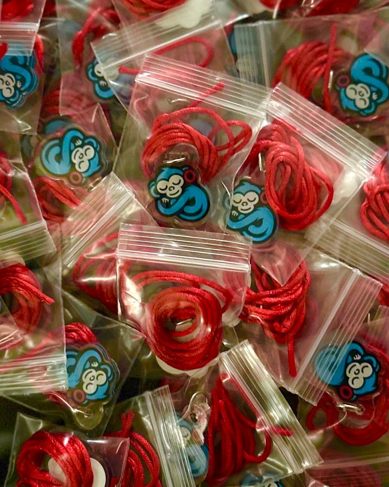 Sleeping monkey necklaces in postage stamp bags 