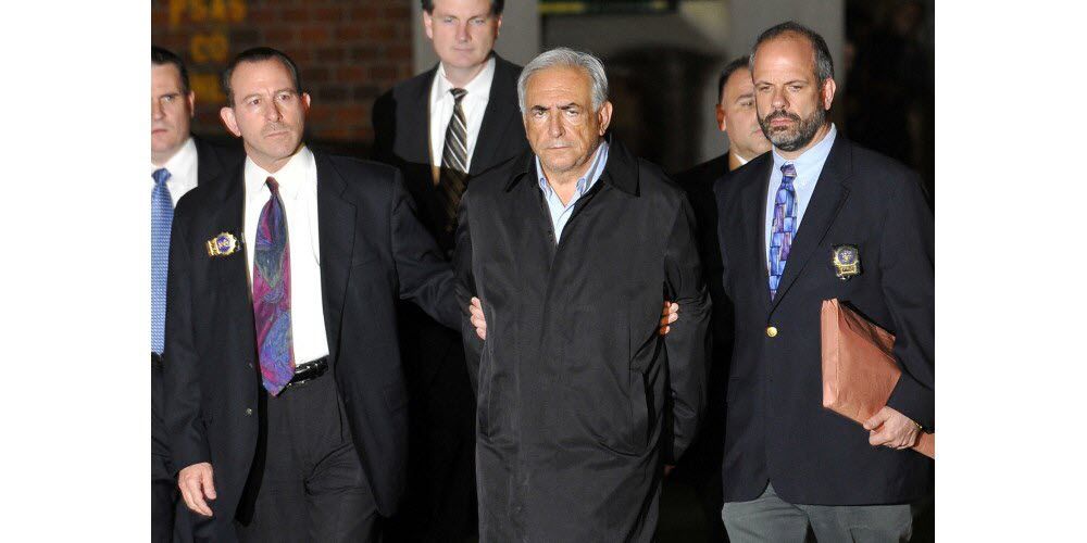 Image de l'arrestation de DSK dans la nuit du 14 au 15 mai 2011, à la sortie d'un commissariat de Harlem (New-York), les traits tirés, entouré de 2 policiers
Source : photo Jewel SAMAD / AFP
