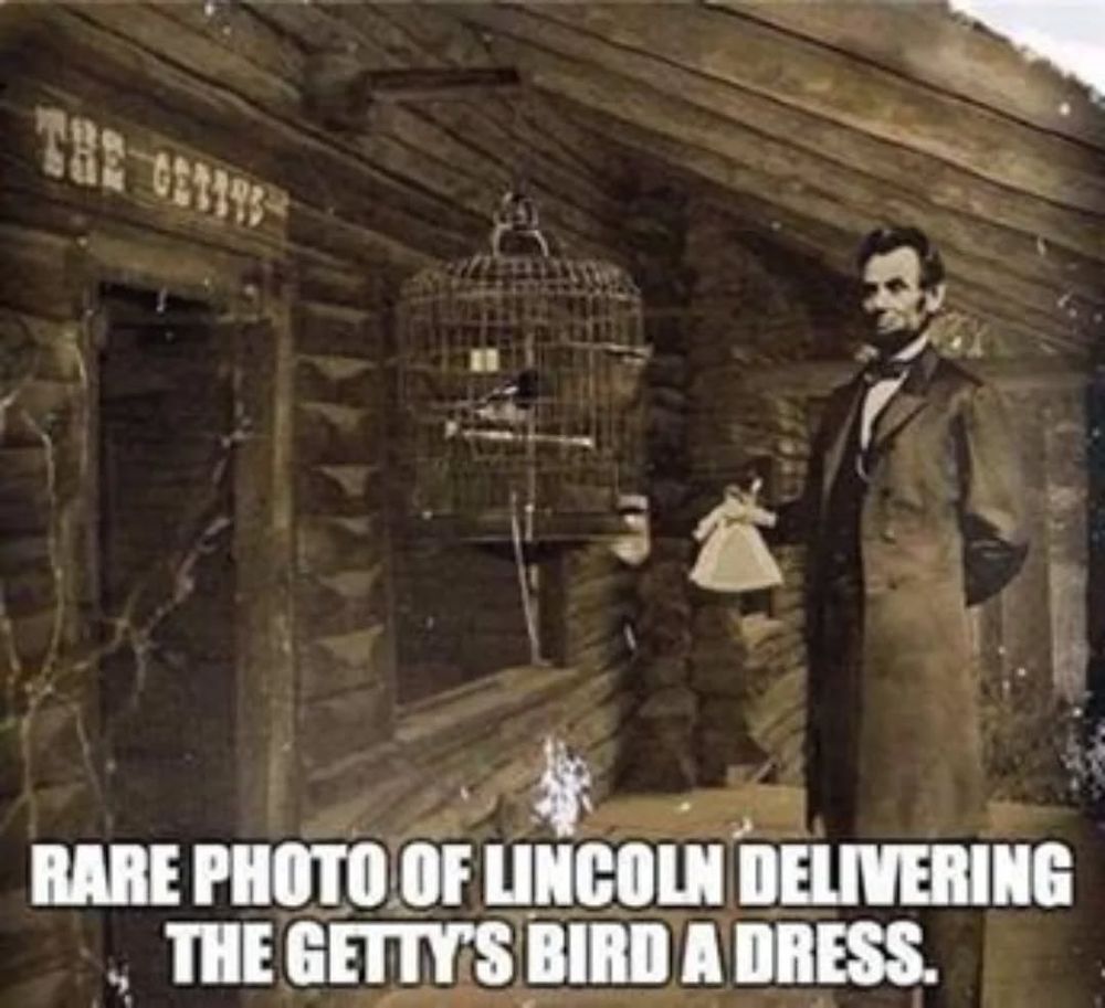 schwarz-weiß Bild von Lincoln der ein Puppenkleid in der rechten Hand hält, vor ihm ist ein Vogel in einem Käfig, beide sind vor einem Holzhaus über dessern Tür "The Gettys" steht. auf dem unterem Bildrand der Text "rare photo of Lincoln delivering the Getty's bird a dress"