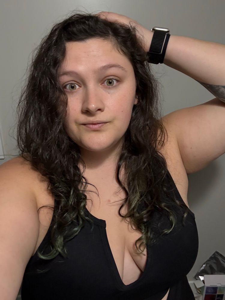 A selfie of me with primarily dark brown hair and green tips on the end