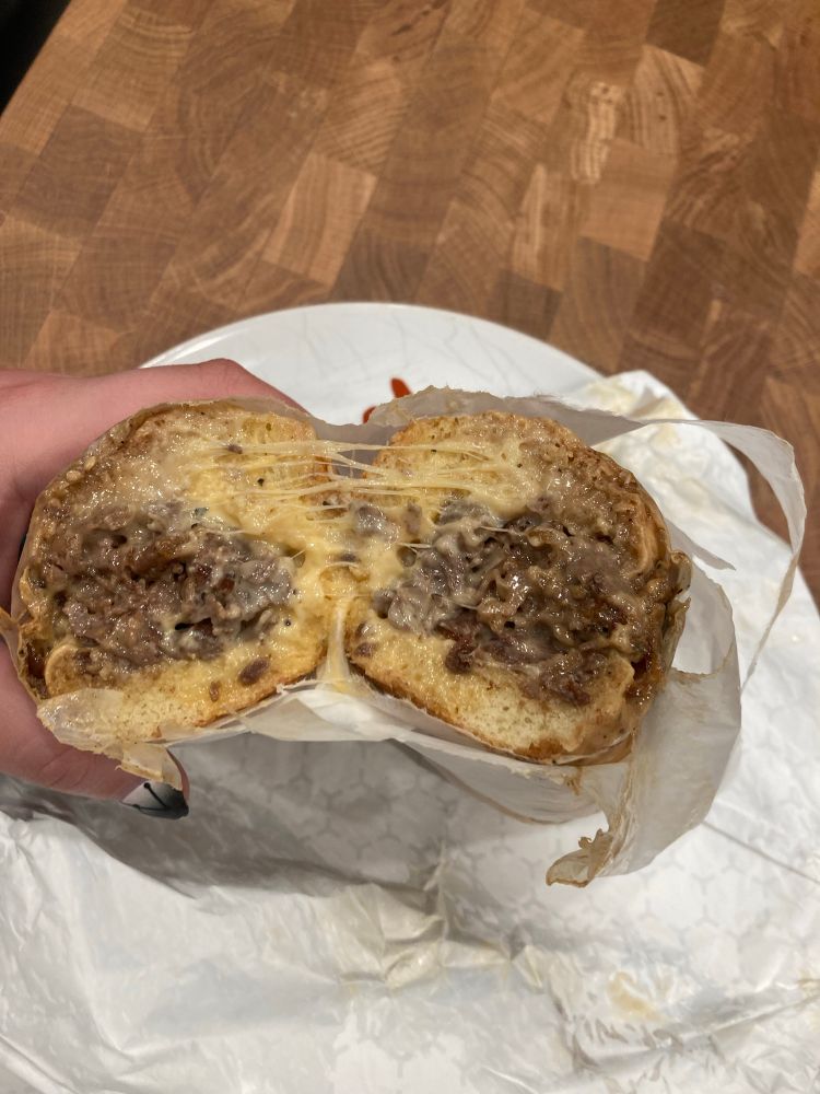 Just an incredibly robust side profile of a cheesesteak. Thick beautiful cheese stretches between the two pieces over an abundance of thinly chopped steak 