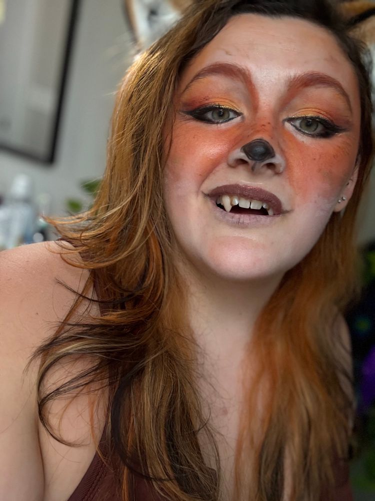  Selfie of me in fox makeup and cute fox ears that match my hair. Also, a lot cut crop top for the girlies I have my mouth open with visible fangs 