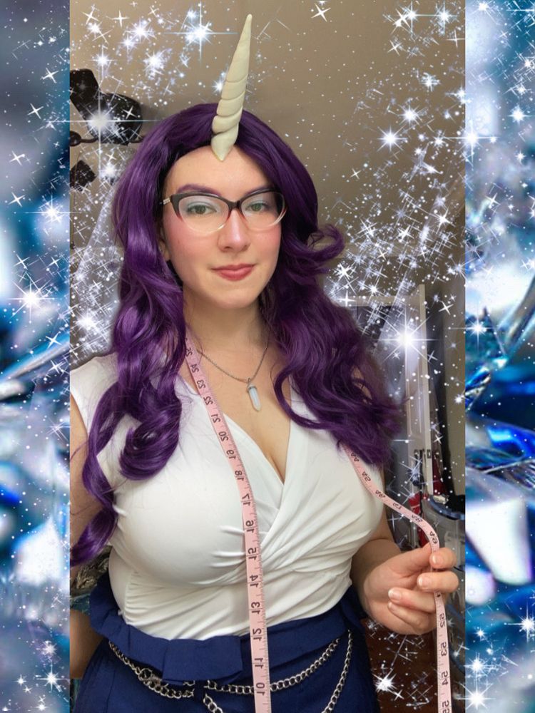 the first of four pictures of my Rarity cosplay from My Little Pony. I have light skin, wearing a curly purple wig, white top, navy bottoms with a silver chain belt, a necklace with a crystal pendant, and red cat eye glasses. i also have a white unicorn horn on my forehead and am holding a pink measuring tape. the photos are edited to be uniform size with blue borders and sparkle or diamond effects in the background.