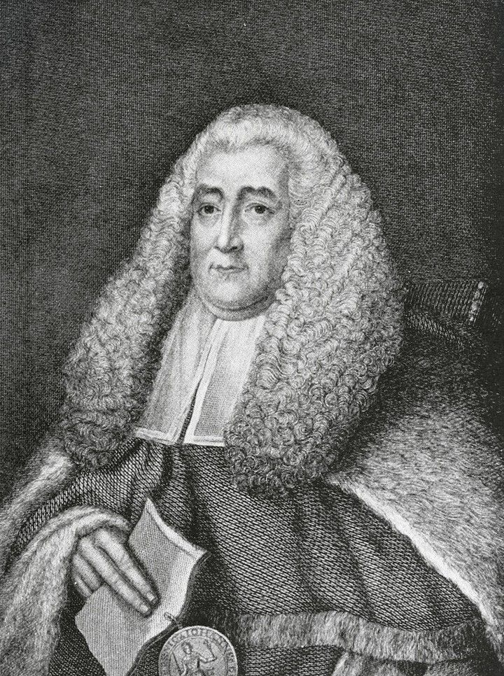 A black and white etching of a man wearing a long white curly wig and elaborate robes. He is holding a piece of paper with a seal in his hands.