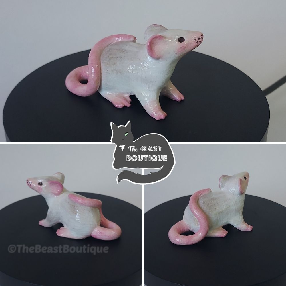 a collage showing a white rat figurine with  a pink tail, muzzle, paws, and ears, from multiple angles. 

the shop name, the beast boutique, watermarks the image. 