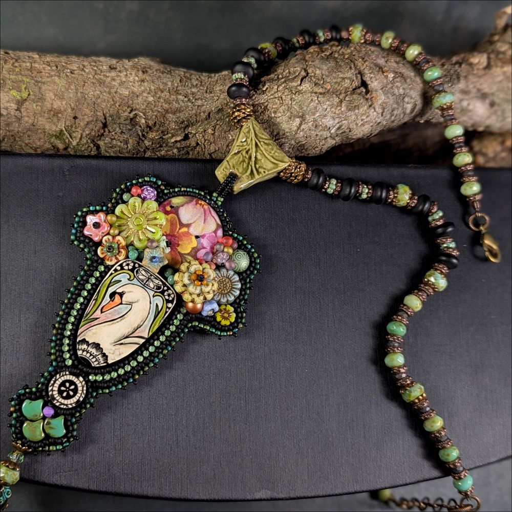 Bead embroidery necklace with swan surrounded by flowers made by artist Susan Phillips - https://www.etsy.com/listing/4306330584/swans-garden-party-days-of-joy-and