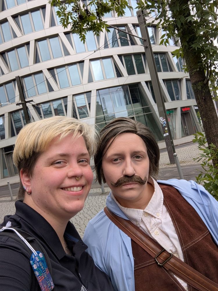 Selfie von Kenni und mit. Kenni im Fotografen Look und ich im Cosplay (ja, auch wenn es alle überrascht, der Bart ist nicht mein eigener/richtiger)