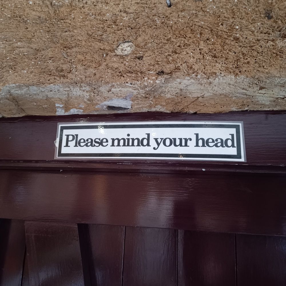 Sign above old doorway "please mind your head"