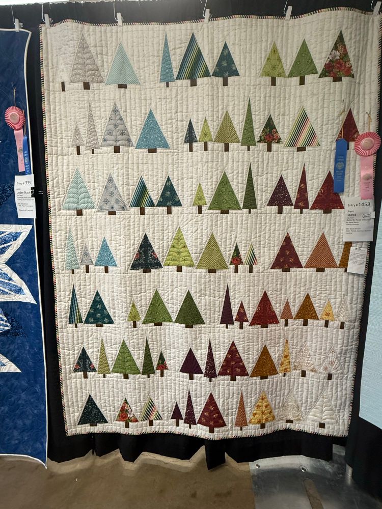 A lovely white quilt with multicolored trees