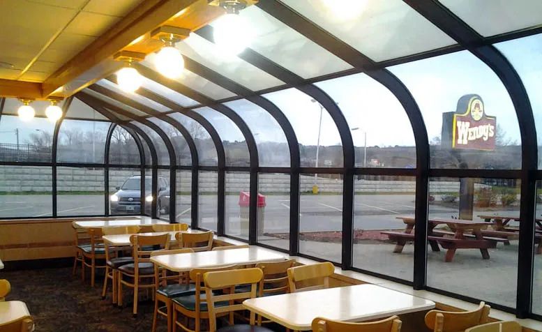 Wendy’s solarium looking out over a parking lot. 