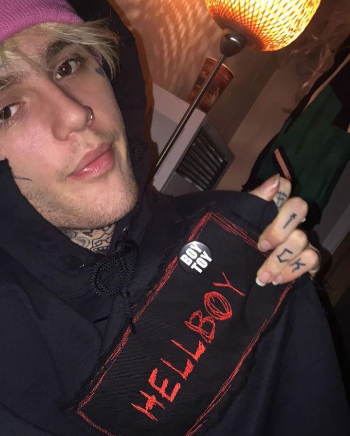 lil peep wearing hellboy merch with pin that says "boytoy"