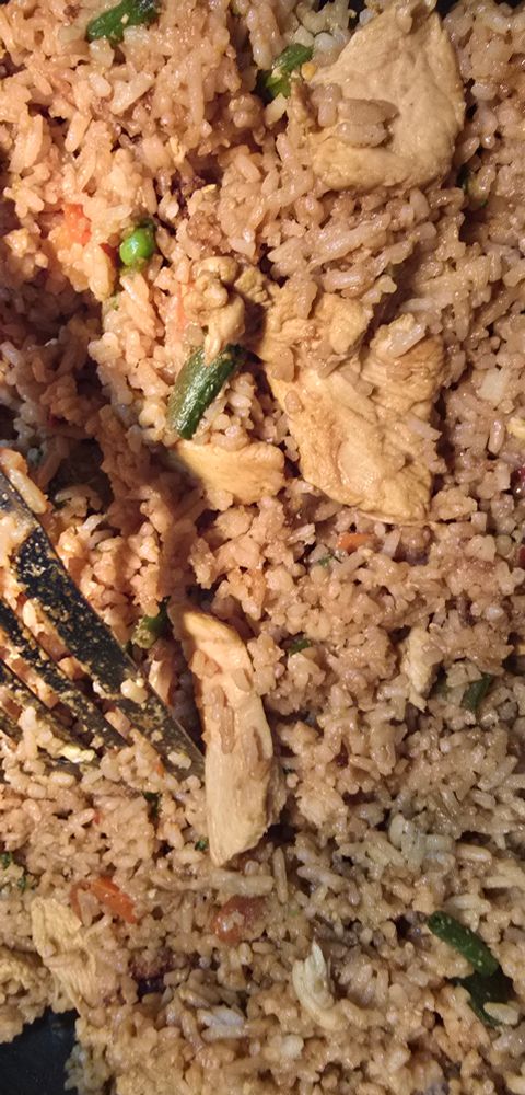 Some fried rice with bits of chicken and various vegetables, it as been seasoned with garlic, turmeric, pepper flakes, and of course soy sauce 