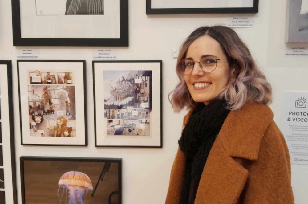 Myself trying to act natural, standing next to the 2 framed Bookwyrms pages at the Cambridge local creatives exhibition.