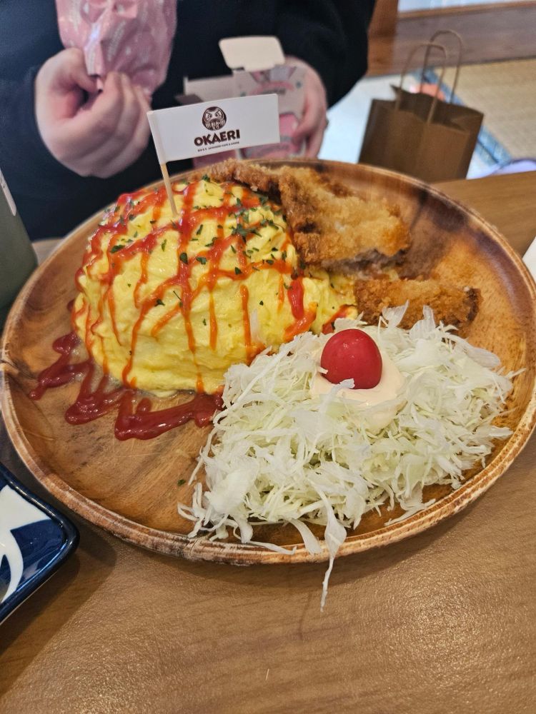 Omelette rice with katsu on a plate and
 a cabbage and mayo concoction on the side 