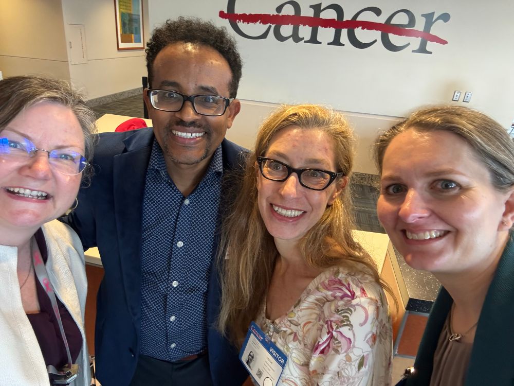 Myself, Bisrat Debeb, Jennifer Maynard, Annalee Nguyen in from of the MDACC line through cancer logo. 