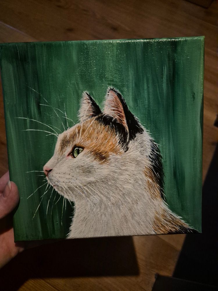 Schilderij van een lapjeskat met prachtig groene ogen op een groene achtergrond