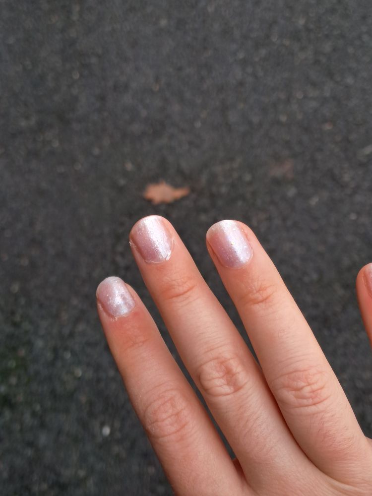 Zoom sur ma main j'ai du vernis rose a paillettes.