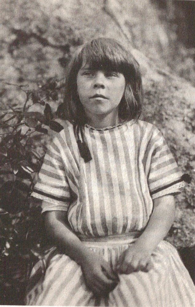 Black and white photo of young Tove wearing a stripy dress and looking rather serious. 