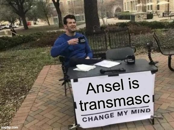 Meme image of divorced man Steven Crowder at a desk bearing a sign that reads "Ansel is transmasc. Change my mind"